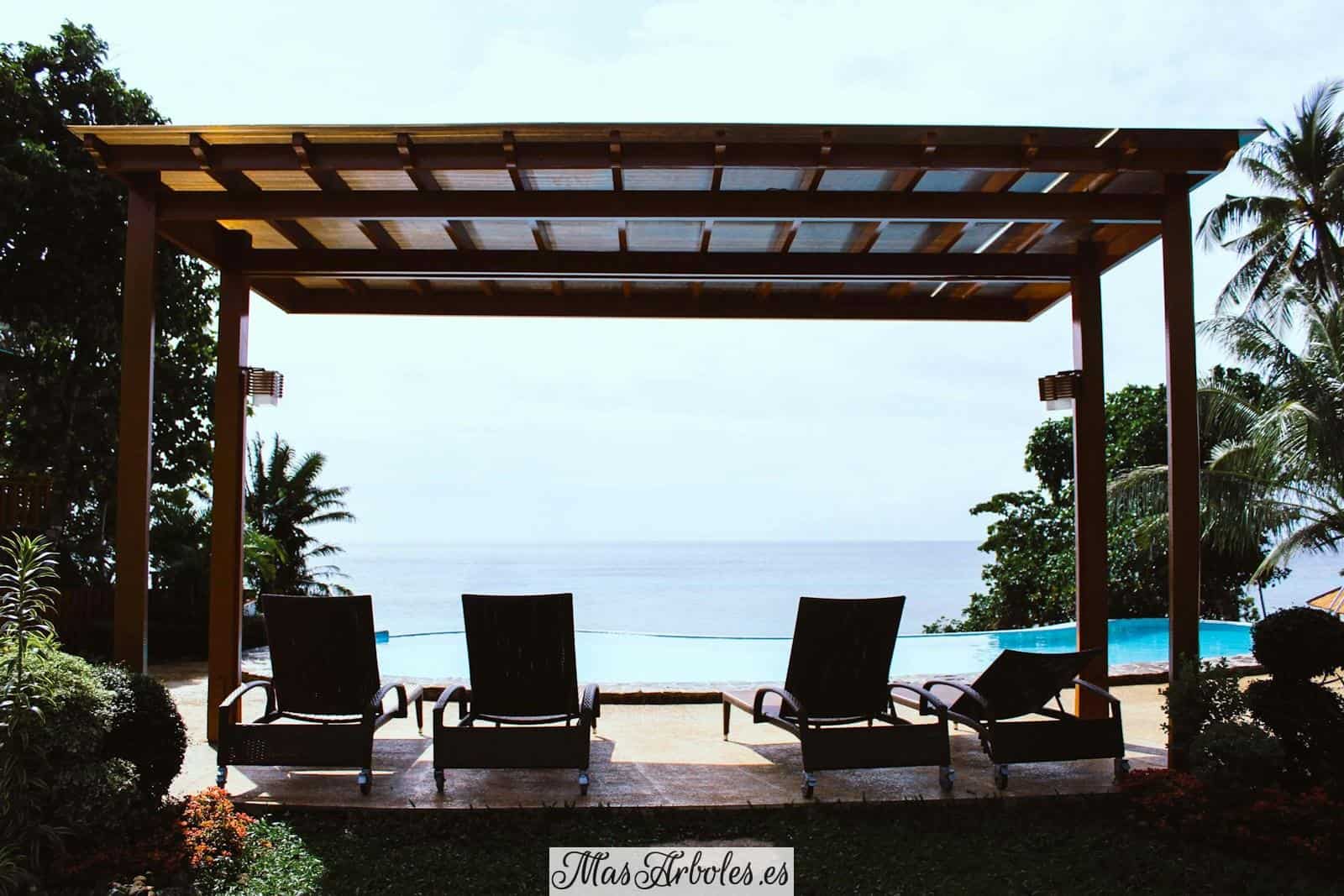 photo of four loungers under gazebo facing swimming pool